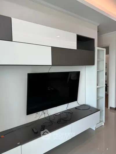 Modern living room with sleek TV unit and wall-mounted storage