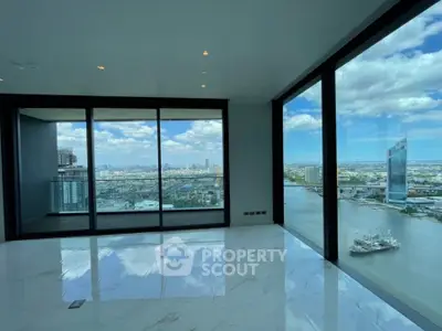 Stunning high-rise apartment with panoramic city and river views, featuring floor-to-ceiling windows.