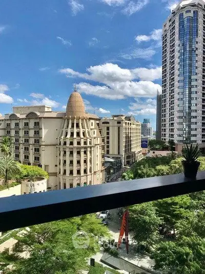 Stunning cityscape view from a modern balcony with lush greenery and iconic architecture.