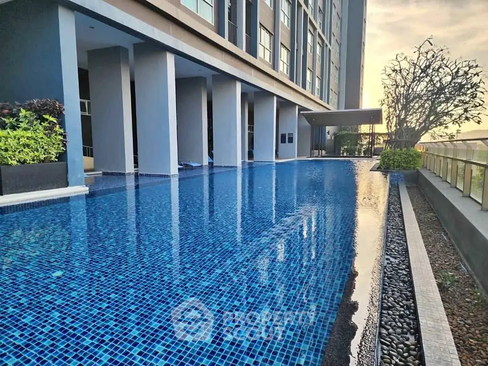 Luxurious high-rise building with stunning poolside view at sunset, perfect for relaxation and leisure.