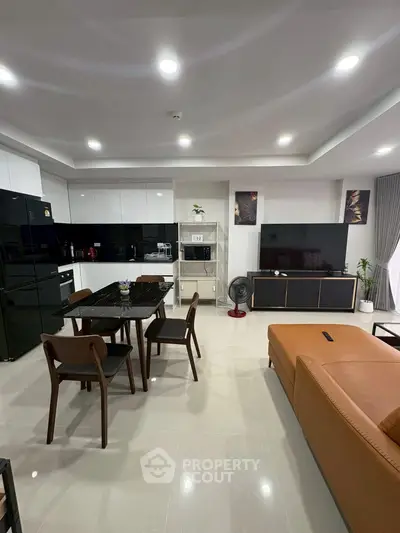 Modern open-layout living room with sleek kitchen and stylish furniture