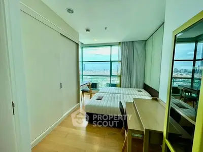 Modern bedroom with stunning city view, featuring sleek furniture and large windows for natural light.