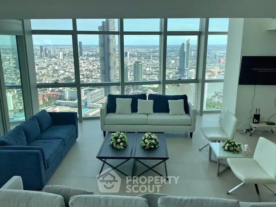 Luxurious living room with panoramic city views and modern furnishings in high-rise apartment.