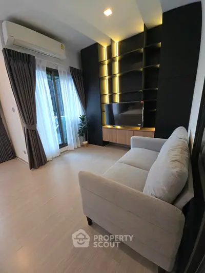 Modern living room with sleek TV unit and cozy sofa, featuring elegant lighting and large window drapes.