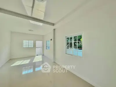 Spacious sunlit room with large windows and glossy tiled floors, perfect for modern living.