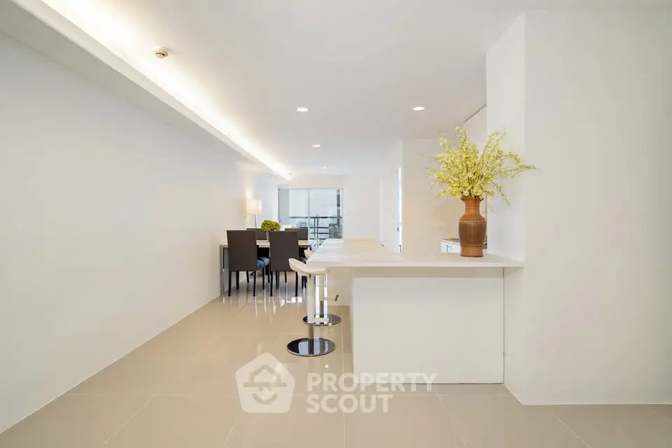 Modern open-plan dining area with sleek white interiors and stylish furniture