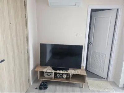 Modern living room with sleek TV setup and air conditioning unit.