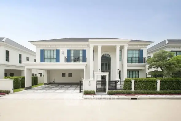 Luxurious modern mansion with grand entrance and manicured landscaping in upscale neighborhood.