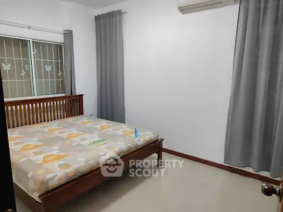 Spacious bedroom with modern decor and large window for natural light.