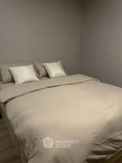 Cozy and minimalist bedroom with neutral tones and plush bedding.