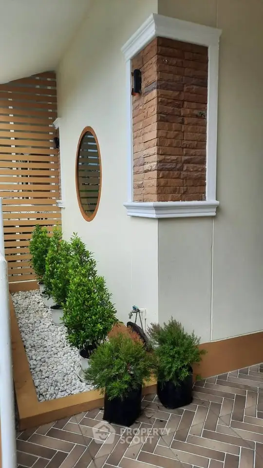 Charming balcony with elegant brick accents and lush greenery for a serene outdoor retreat.