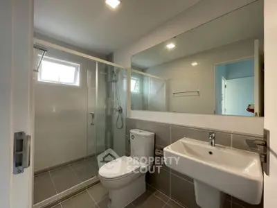 Modern bathroom with glass shower and sleek fixtures in a contemporary home.