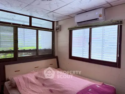 Cozy bedroom with air conditioning and large windows for natural light