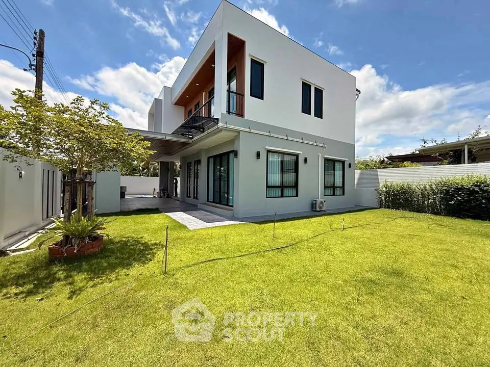 Modern two-story house with spacious green lawn and contemporary design.