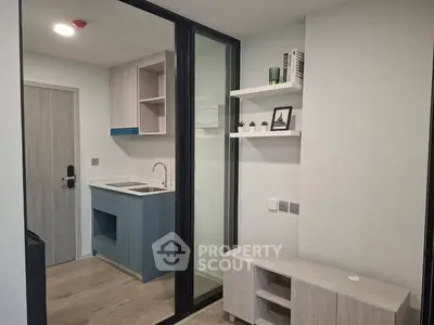 Modern compact kitchen with sleek design and open shelving in a cozy apartment.