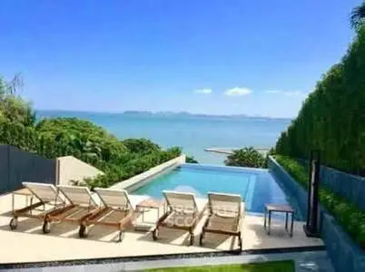 Luxurious beachfront pool with stunning ocean view and sun loungers, perfect for relaxation.