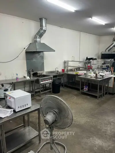 Spacious commercial kitchen with stainless steel appliances and ample workspace, ideal for culinary ventures.