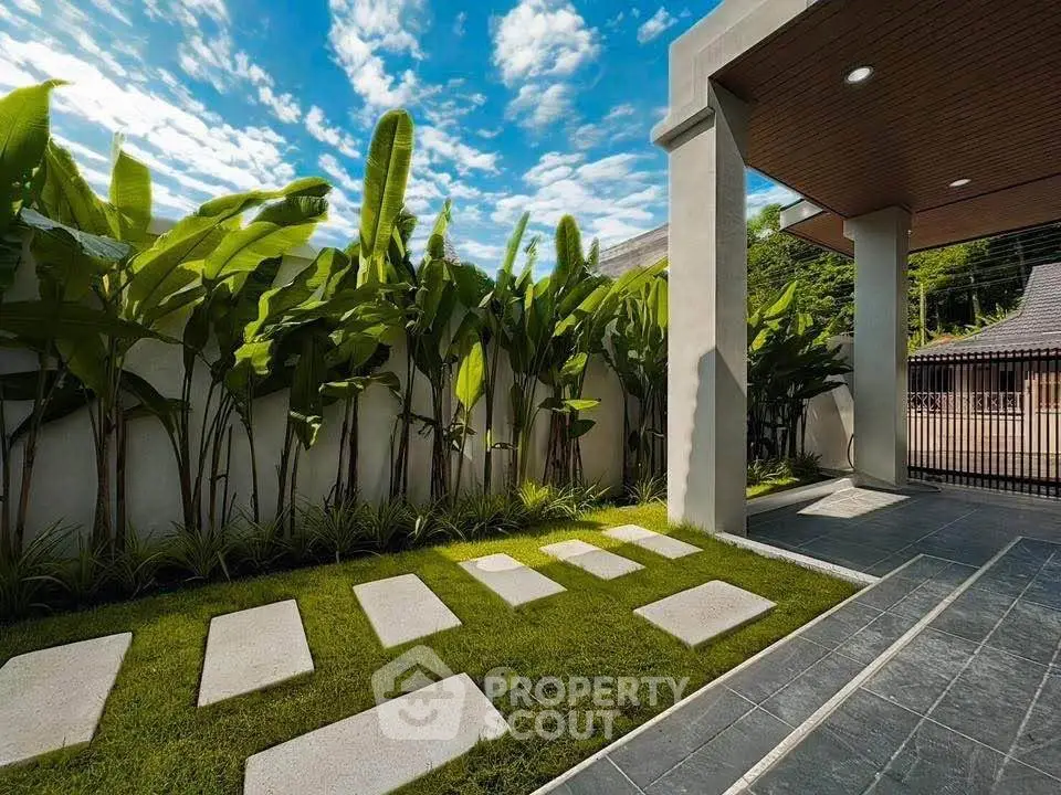 Luxurious modern garden with sleek pathway and lush greenery under a vibrant blue sky.