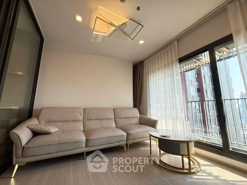 Modern living room with elegant sofa and large windows offering city views