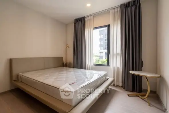 Modern bedroom with stylish bed and large window offering natural light