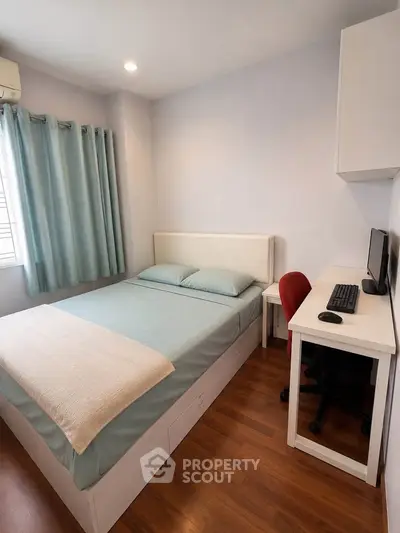Cozy bedroom with modern furnishings and workspace, ideal for comfortable living.