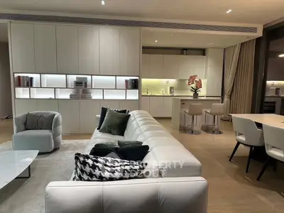 Luxurious modern living room with open kitchen, elegant furniture, and ambient lighting