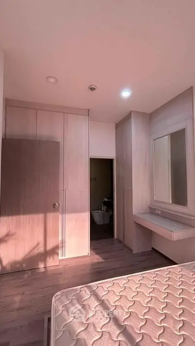Spacious bedroom with built-in wardrobe and vanity in modern apartment