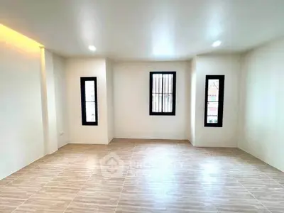 Spacious and bright living room with modern tile flooring and large windows.