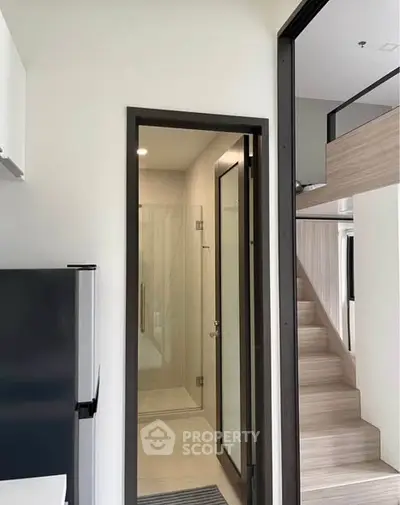 Modern compact apartment with sleek shower and loft-style staircase