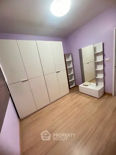 Spacious bedroom with modern wardrobe and stylish mirror in a cozy apartment.