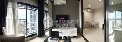 Modern living room with balcony and dining area, featuring sleek furniture and natural light.