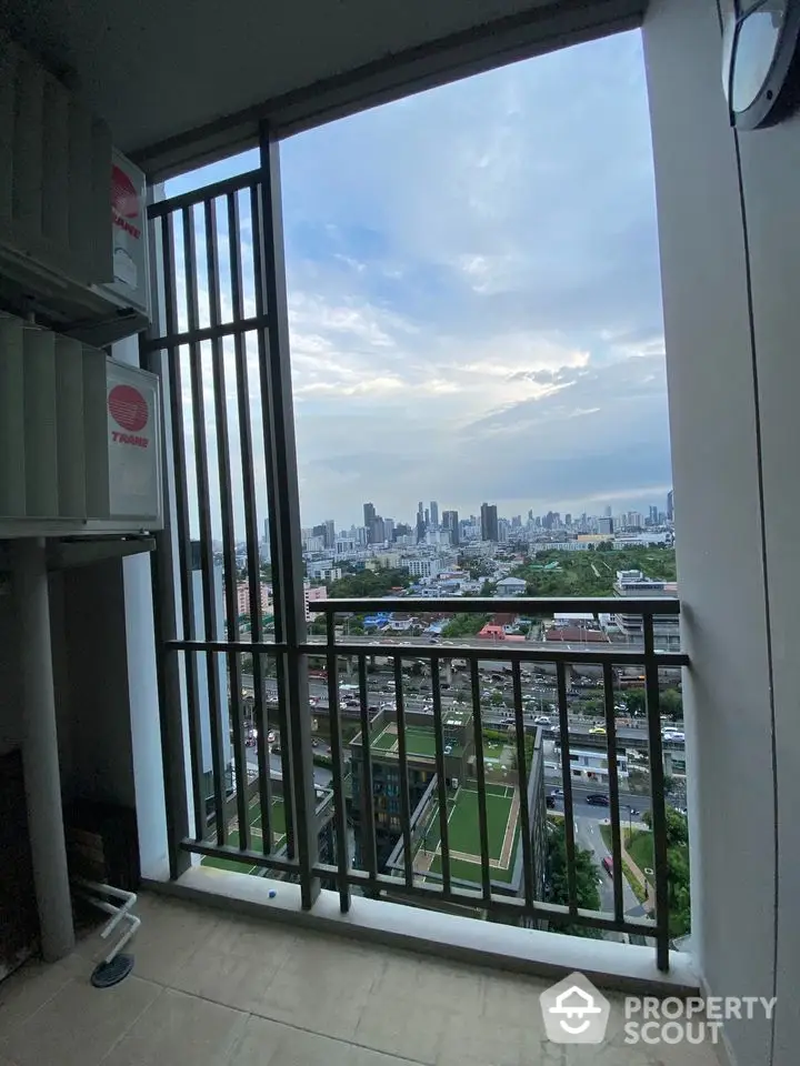 Stunning cityscape view from high-rise balcony with modern railing design.