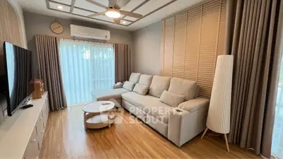 Modern living room with cozy sofa, wooden flooring, and large window with curtains.