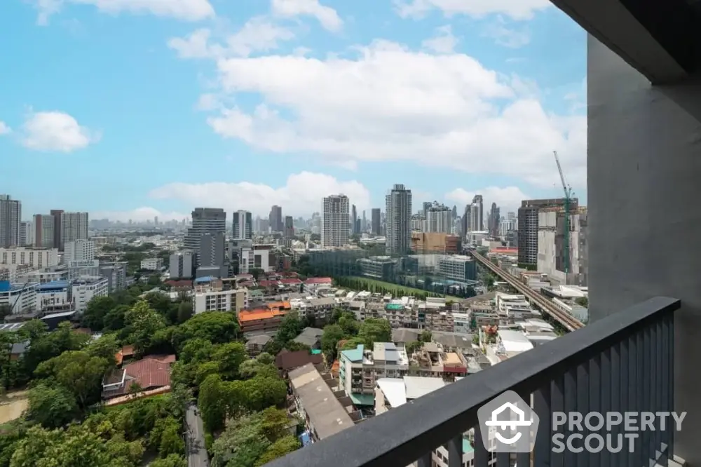 Stunning cityscape view from high-rise balcony overlooking urban skyline and lush greenery.