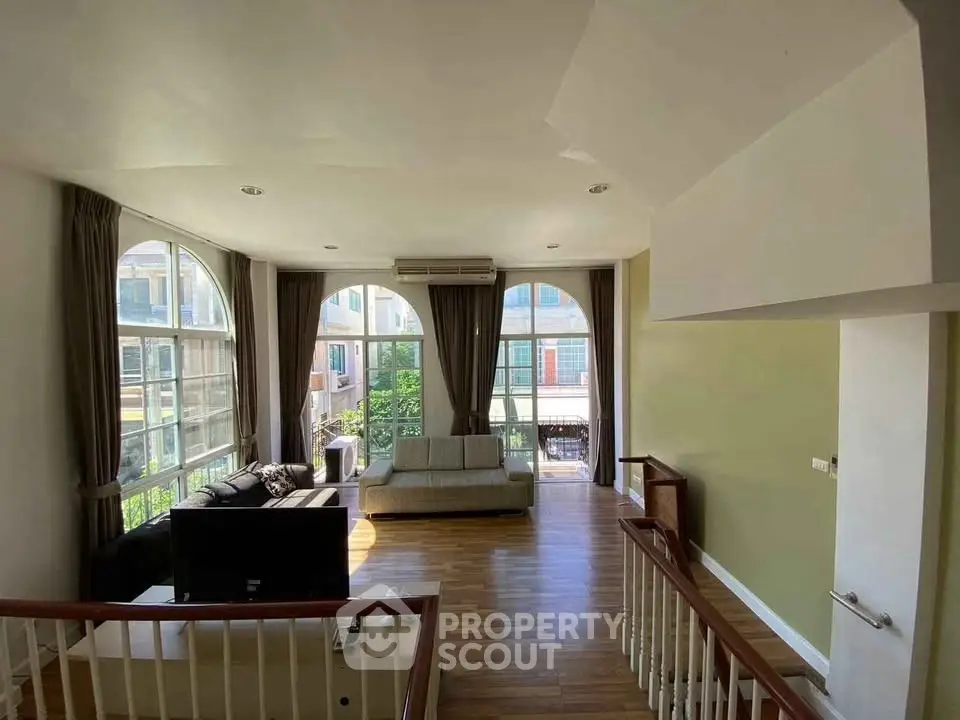 Spacious living room with large windows and wooden flooring