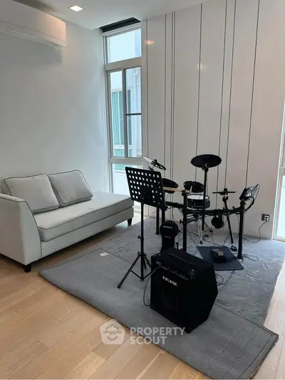 Modern living room with drum set and cozy sofa, perfect for music enthusiasts.