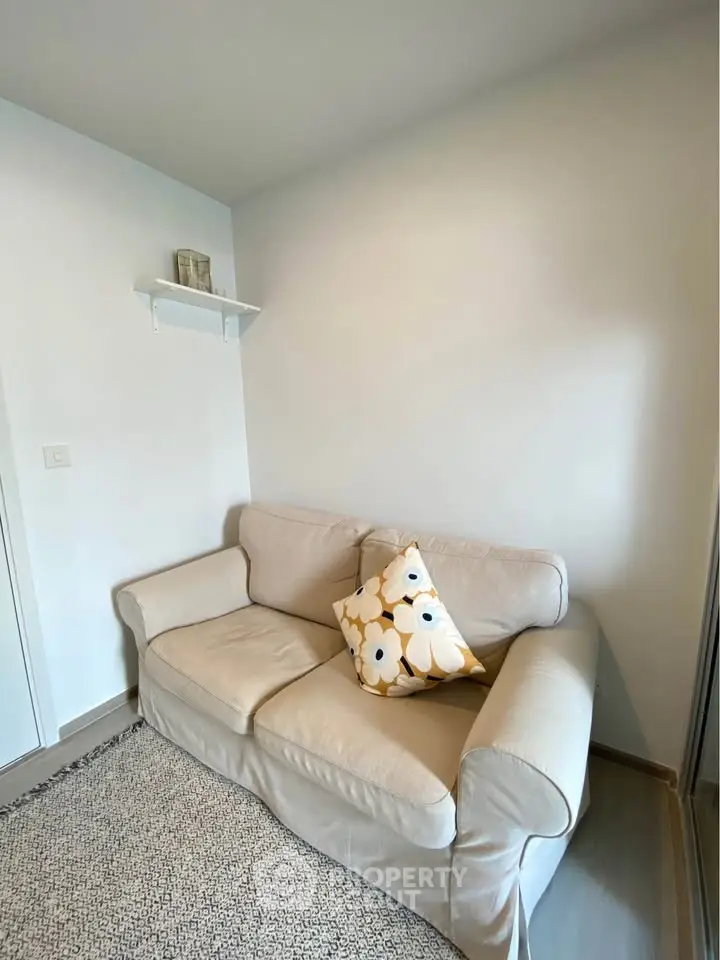Cozy small living room with beige sofa and decorative cushion