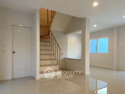 Spacious modern interior with sleek staircase and bright lighting