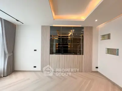 Modern living room with elegant ceiling lights and stylish wooden flooring.