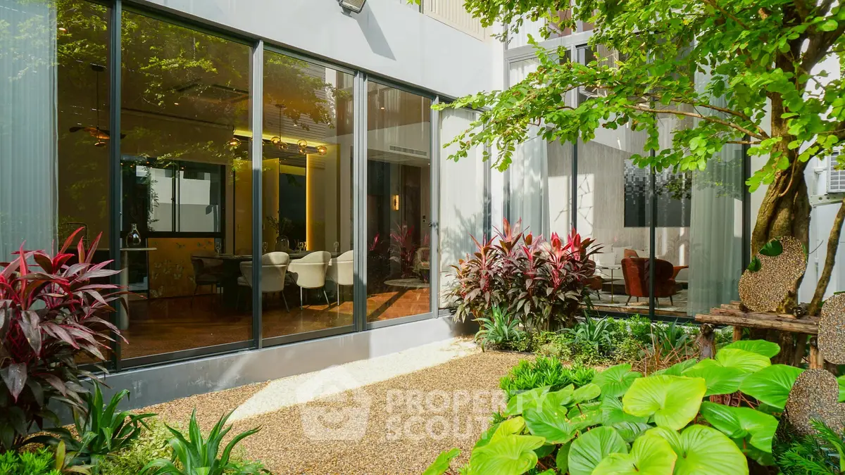 Modern home with lush garden and large glass windows for natural light