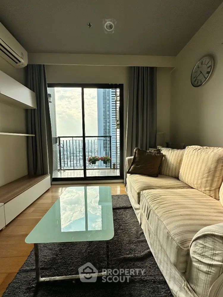 Modern living room with glass coffee table and city view balcony
