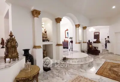 Luxurious marble-floored living room with elegant columns and classic decor