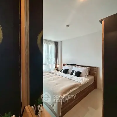 Cozy bedroom with modern decor and large window for natural light.