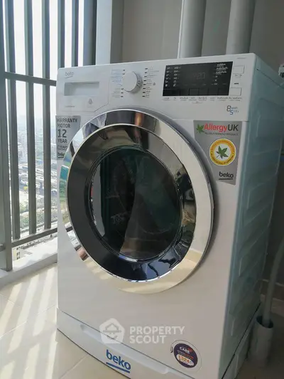 Modern washing machine in a bright laundry area with city view, perfect for urban living convenience.