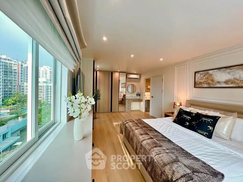 Luxurious bedroom with large window and modern decor in high-rise apartment