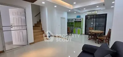 Spacious open-plan living room with modern kitchen and dining area, featuring sleek design and ample natural light.