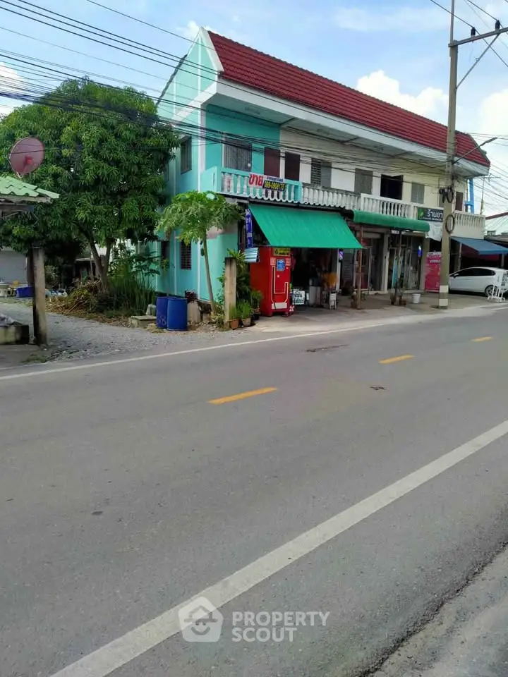 Charming two-story building with vibrant facade and street view, ideal for small business or residence.