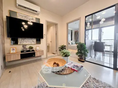 Modern living room with stylish decor and large TV, featuring open layout and balcony view.