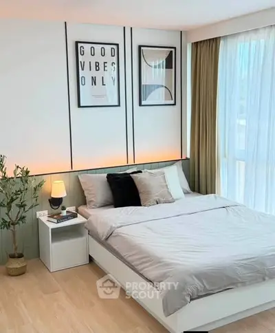 Modern bedroom with stylish decor and large windows offering natural light.