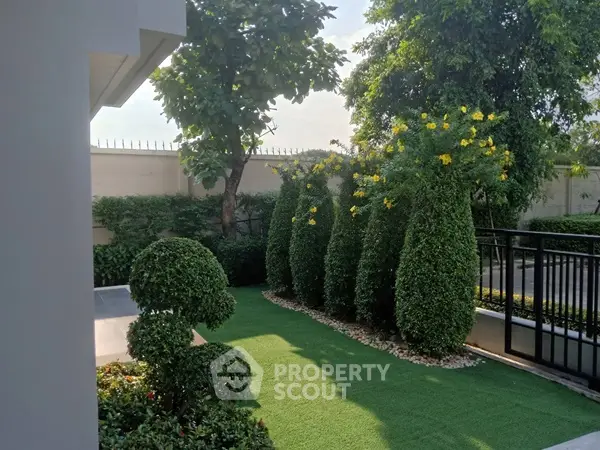 Beautifully landscaped garden with lush greenery and manicured shrubs in a serene residential setting.